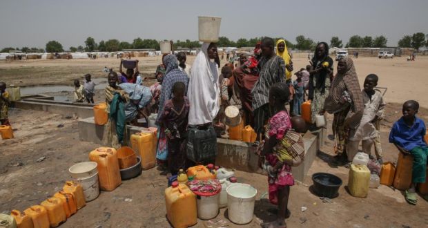 Displaced people collect water in Muna Garage camp for the displaced on the outskirts of Maiduguri, northeast Nigeria. Photograph: Sally Hayden