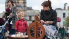 Jean Moran spins yarn from raw fleece, watched by Hans Constable Herriott,  in Smithfield in Dublin as Culture Night gets under way. Photograph: Dave Meehan