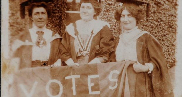 Hanna Sheehy Skeffington, left, Kathleen Shannon and Kate Sheedy in their graduation robes and mortar boards, carrying a banner saying “Votes” (for women)