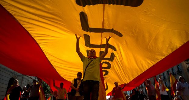 Protesters hold a giant Spanish flag during a demonstration called by “Societat Civil Catalana” (Catalan Civil Society) to support the unity of Spain on October 8, 2017 in Barcelona. JORGE GUERRERO/AFP/Getty Images