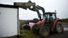 A tractor is positioned to hold a roof down on a farm as as  Ophelia hits the Co Clare peninsula of Loop Head. Photograph: Clodagh Kilcoyne/Reuters