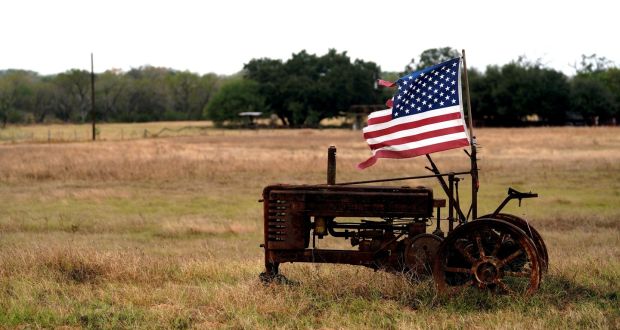 A tattered US flag flies on an old tractor in a farm field outside Sutherland Springs, near the site of the shooting at the First Baptist Church in Texas. Photograph: Reuters/Rick Wilking 