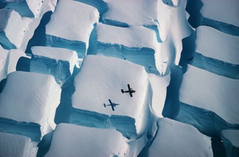   Cubes of iced sugar from Peter Convey, who was named overall winner and winner in the category Earth Sciences and Climatology. The photo, taken in early 1995 during a flight over the English coast (south of the Antarctic Peninsula) at about 74 degrees to the south, illustrates the scale of unusual bidirectional cracks when an ice sheet is stretched in two directions over an underlying elevation. , with a Twin Otter Airplane as a stopover.
