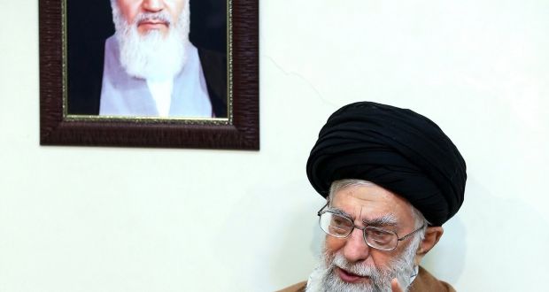 Iranian Supreme leader Ayatollah Ali Khamenei, sitting under a portrait of the late Iranian revolutionary founder Ayatollah Khomeini, as he speaks during a meeting with family members of Iranian martyrs, in Tehran yesterday. Photograph: EPA