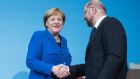 German chancellor and CDU leader Angela Merkel and SPD leader Martin Schulz shake hands in Berlin on Friday following all-night preliminary coalition talks. Photograph: Steffi Loos/Getty Images