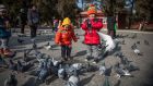 Chinese children feed pigeons at Ditan Park in Beijing: a report by the Shanghai Women’s Federation shows over half of households with one child do not want a second. Photograph: Roman Pilipey 