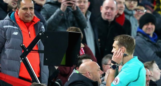 Craig Pawson, match referee, watches the VAR screen before awarding a penalty to Liverpool. Photograph: Alex Livesey/Getty Images