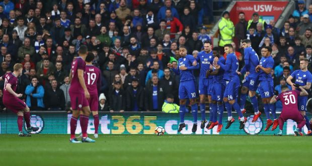 Kevin De Bruyne sends his free kick under the wall against Cardiff city. Photograph: Michael Steele/Getty