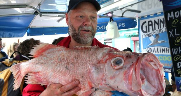 Fishmonger Stefan Griesbach with a golden redfish at his stall at the Saturday market in Galway city. Photograph: Joe O’Shaughnessy