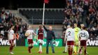 A fan holds up a corner flag after invading the pitch during the game between West Ham and Burnley at the London Stadium. Photograph: David Klein/Reuters 