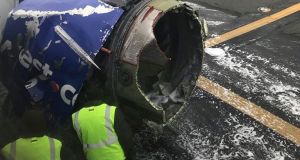 The engine on a Southwest Airlines plane is inspected as it sits on the runway at  Philadelphia International Airport after it made an emergency landing. Photograph: Amanda Bourman via AP