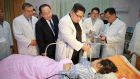 North Korean leader Kim Jong-un speaking to an injured Chinese tourist at a hospital during a visit with Chinese ambassador to North Korea Li Jinjun (left), at an undisclosed location in North Korea. Photograph: AFP Photo/ KCNA via KNS