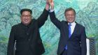 Kim Jong-un and Moon Jae-in raise their hands after signing on a joint statement at the border village of Panmunjom in South Korea. Photograph: Korea Broadcasting System via AP