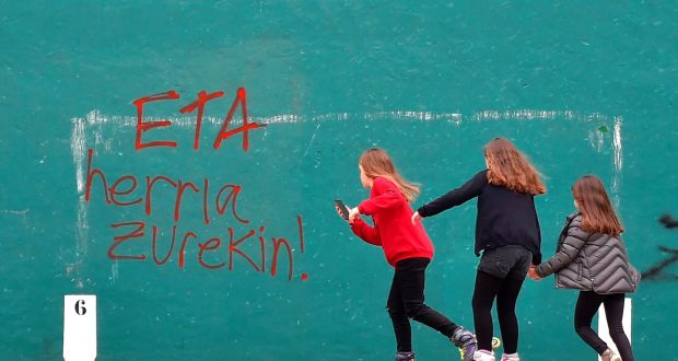 Girls skate next to a graffiti reading in Basque “ETA, the people with you” in the Spanish Basque village of Hernani. The militant separatist group announced its dissolution earlier this month. Photograph: Ander Gillenea/AFP/Getty Images