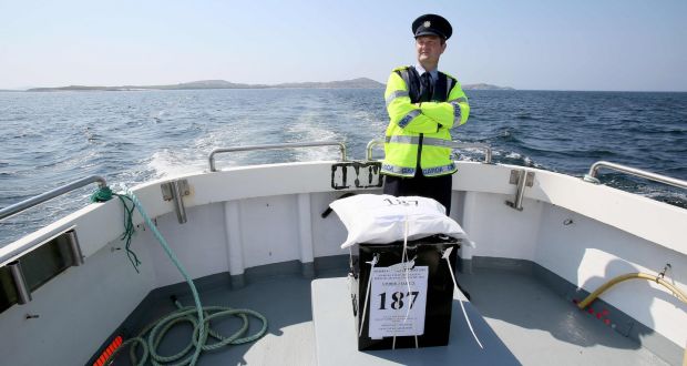 Garda Pat McElroy stands with the sealed ballot box as he travels back to the mainland from Gola Island, off the Donegal coast, after voting in the abortion referendum was completed on Thursday. The inhabitants of Gola island voted a day earlier than the rest of the country. Photograph: Paul Faith/AFP/Getty Images