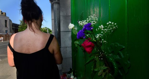 A former resident outside the laundry at Sean McDermott Street, where there are  posies and a bouquet left at the door in memory of women who spent their lives inside. Photograph: Cyril Byrne / The Irish Times