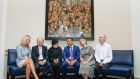 Helen McEntee, Eamon Mallie, Noel Murphy, Leo Varadkar, Katherine Zappone and Declan McGrath pose in front of Murphy’s portrait of all the women members of the Oireachtas.