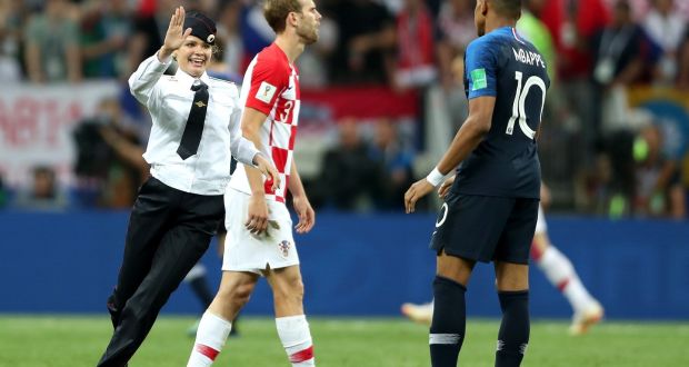 A member of Pussy Riot  runs towards Kylian Mbappe of France during the band’s pitch invasion in Sunday’s World Cup final in Moscow. Photograph:   Clive Rose/Getty Images
