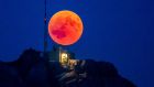 The blood moon rises behind the Saentis Alpstein, Canton of Appenzell, Switzerland, 27 july 2018. Photograph: Christian Merz/EPA.