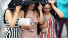 Racegoers shelter from the rain on Ladies Day at Galway Racecourse. Photograph: Brian Lawless/PA