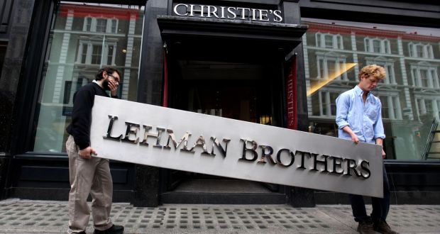 Two employees of Christie’s manoeuvre the Lehman Brothers corporate logo as it went on auction in September 2010 in London. Photograph: Oli Scarff/Getty Images