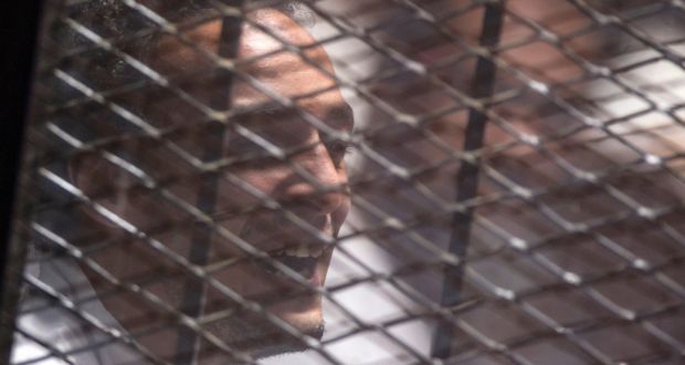  Egyptian photojournalist Mahmoud Abu Zeid, better known as Shawkan, reacts behind a grill after a verdict sentenced him to five years in Cairo, Egypt. Photograph: Mohamed Hossam/EPA