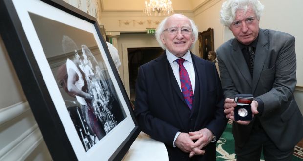 The President receives a commemorative silver Rory Gallagher coin commissioned by the Central Bank, above, with Rory Gallagher’s brother Dónal. Photograph: Maxwell’s 