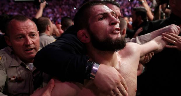 Khabib Nurmagomedov is restrained as  he tries to continue his brawling outside the octagon at UFC 229 in Las Vegas. Photograph: John Locher/AP