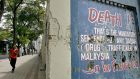 A pedestrian  walks past a wall carrying a message highlighting Malaysia’s mandatory death penalty for drug trafficking in Kuala Lumpur. Photograph:   Tengku Bahar/AFP/Getty Images