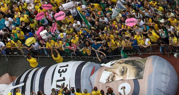 Supporters of Brazilian right-wing presidential candidate Jair Bolsonaro with a giant inflatable doll known as “Pixuleco”, representing former President Luiz Inacio Lula da Silva, with a mask of presidential candidate Fernando Haddad, in Sao Paulo. Photograph: Getty Images