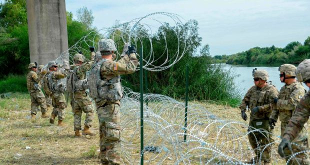US soldiers at Hidalgo, Texas,  apply 300 metres of wire on the Mexico border. Photograph: ALEXANDRA MINOR/AFP/Getty Images