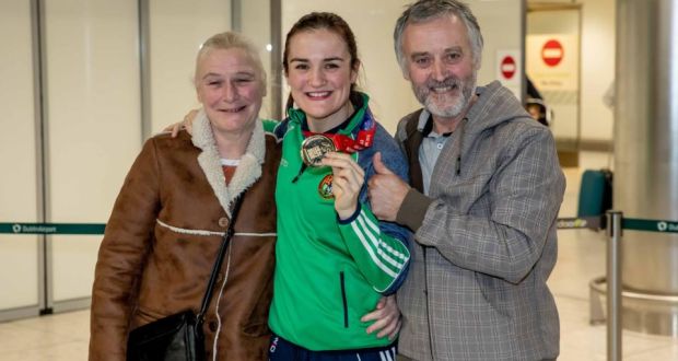 World champion Kellie Harrington shows off her gold medal alongside her parents  Yvonne and Christy on her return to Dublin airport on Sunday. Photograph: Morgan Treacy/Inpho
