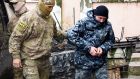 A Ukrainian sailor (right) is escorted by a Russian intelligence agency FSB officer to a courtroom in Simferopol, Crimea on  Tuesday. Photograph: AP Photo