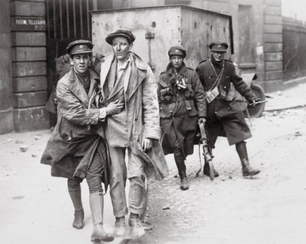 One of the wounded rebels is brought out of the smoking and burning Four Courts building after the surrender to the Free State troops. Photograph: Getty Images