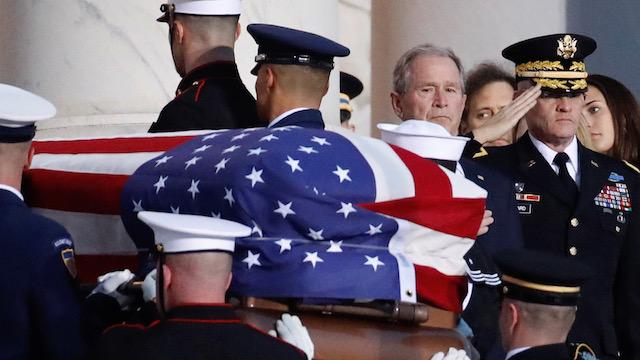 George W Bush watches as his father's coffin arrives at US Capitol