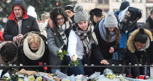  People light-up candles and deposit flowers during a gathering around a makeshift memorial at Place Kleber, in Strasbourg on Sunday to pay a tribute to the victims of Strasbourg’s attack. Photograph: Sebastien Bozon/AFP/Getty Images