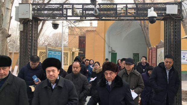 Imams and government officials pass under security cameras as they leave the Id Kah Mosque during a government organised trip in Kashgar, Xinjiang, China. Photograph: Ben Blanchard/Reuters