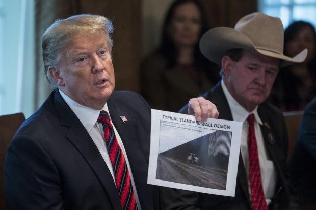
US president Donald Trump speaks while holding a photograph of a border wall during a roundtable discussion on border security at the White House in Washington, DC on January 11th. Judges, law enforcement officers, NASA engineers, weather forecasters and office staff were among some 800,000 federal workers who missed their first paychecks on Friday as a result of the ongoing shutdown Photographer: Zach Gibson/Bloomberg