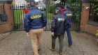 Gardaí and an officer from the National Crime Agency in the UK at a property in the Tamworth area on Saturday. Photograph: National Crime Agency