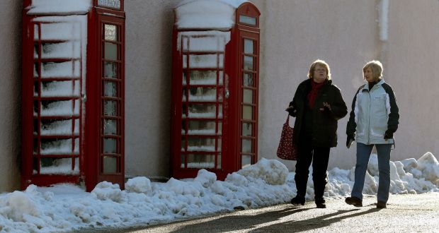 Women walk past snow-covered phone boxes in Braemar in the Scottish Highlands. Photograph: Andrew Milligan/PA Wire