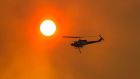 Water bombing helicopters have been regularly deployed in recent weeks in an attempt to put out bushfires in Tasmania.  Photograph: Heath Holden/Getty Images