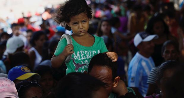 Venezuelans wait for a free lunch at a migrant shelter on the outskirts of Cúcuta, on the Colombian-Venezuelan border. Photograph: Edgard Garrido/Reuters