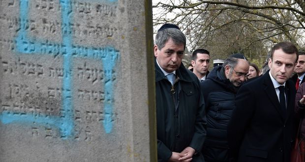 French President Emmanuel Macron visits the vandalised Jewish cemetery in Quatzenheim, eastern France, on Tuesday. French residents and public officials from across the political spectrum geared up Tuesday for nationwide rallies against anti-Semitism following a series of anti-Semitic acts, including the swastikas painted on about 80 gravestones at the Jewish cemetery. Photograph: Frederick Florin/ AP