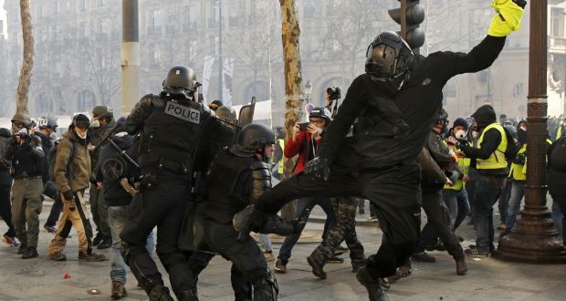 A yellow vest protester hits a riot police officer with his leg on the Champs Élysées during the 18th consecutive national Saturday protest in Paris. Photograph:  Yoan Valat/EPA
