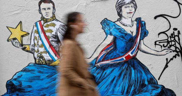 A woman walks past an art work depicting French president Emmanuel Macron and Britain’s prime minister Theresa May  on a wall in Paris. Photograph: Reuters/Christian Hartmann  