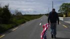 Tommy Haugh carries a US flag to festoon the streets of Doonbeg village ahead of a visit by US president Donald Trump. Photograph: Clodagh Kilcoyne/Reuters