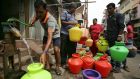 A man uses a hand pump to fill up a container with drinking water as others wait in a queue on a street in Chennai, India. Photograph: P Ravikumar/Reuters