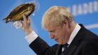 Conservative MP and leadership contender Boris Johnson holds up kipper fish in plastic packaging as he speaks at the final Conservative Party leadership election hustings in London. - Photograph: Tolga Akmen/AFP/Getty Images