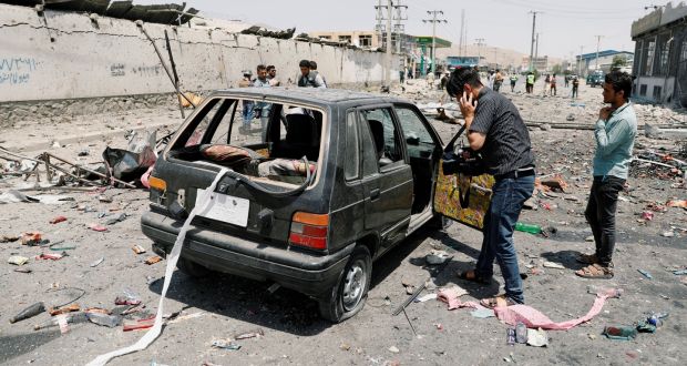 Cameraman films a damaged car at the site of a blast in Kabul. Photograph: Mohammad Ismail/Reuters