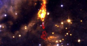 The red contours indicate cm wavelength radio emission from ionised gas produced by shocks. The white cross indicates the position of the massive protostar